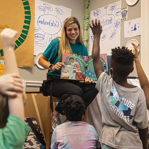 teacher reading a book to students